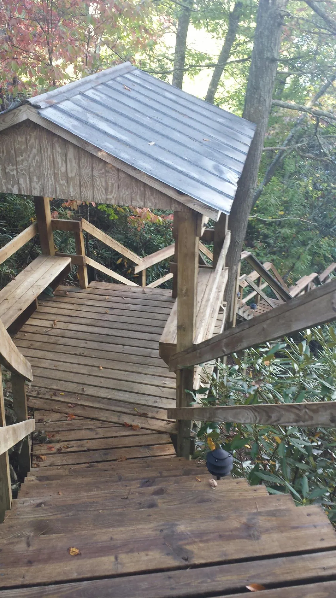 Metal roofed shelter over wooden steps on a wooded walkway — Skylight Repair & Installation work by our crew in Danielson
